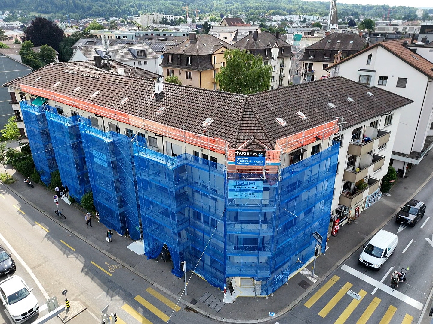 Maler arbeiten auf einem professionellen Fassadengerüst an einem Schweizer Mehrfamilienhaus